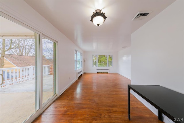 sunroom / solarium featuring radiator heating unit, baseboard heating, and visible vents