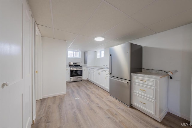 kitchen with light wood-style flooring, appliances with stainless steel finishes, white cabinets, and light countertops