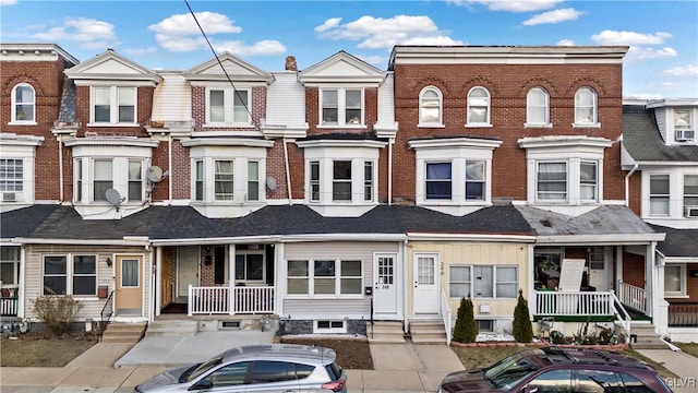 multi unit property with covered porch and brick siding