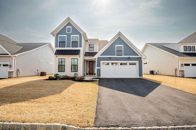 view of front of house featuring metal roof, aphalt driveway, a standing seam roof, cooling unit, and board and batten siding