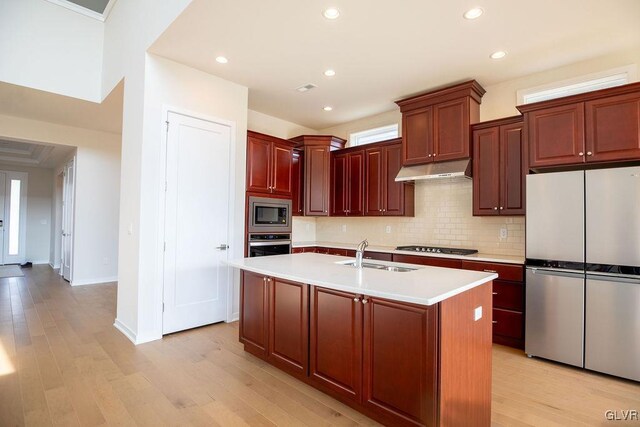 7013 Oak Ln, East Allen Twp, PA 18014 - kitchen with stainless steel appliances, a sink, under cabinet range hood, decorative backsplash, and light countertops