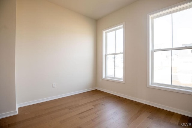 spare room featuring light wood-type flooring and baseboards