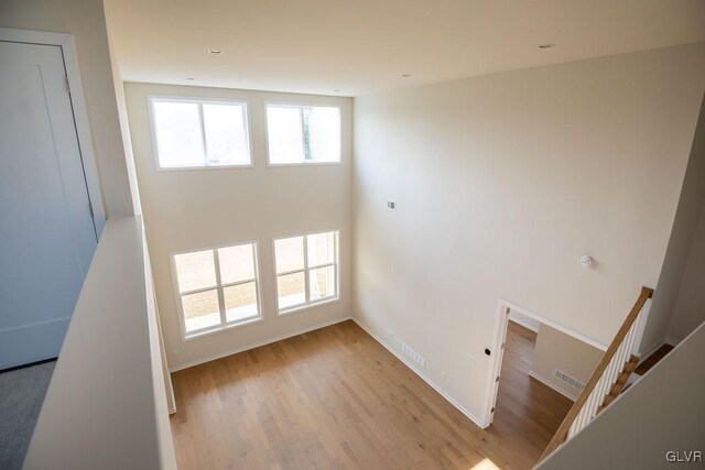 stairs with wood finished floors, visible vents, and baseboards