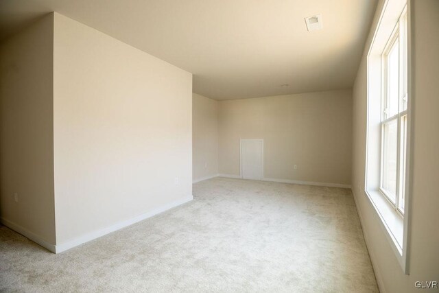 carpeted empty room with visible vents and baseboards