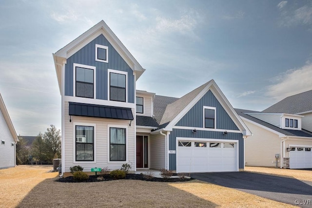 view of front facade with a standing seam roof, metal roof, aphalt driveway, and board and batten siding