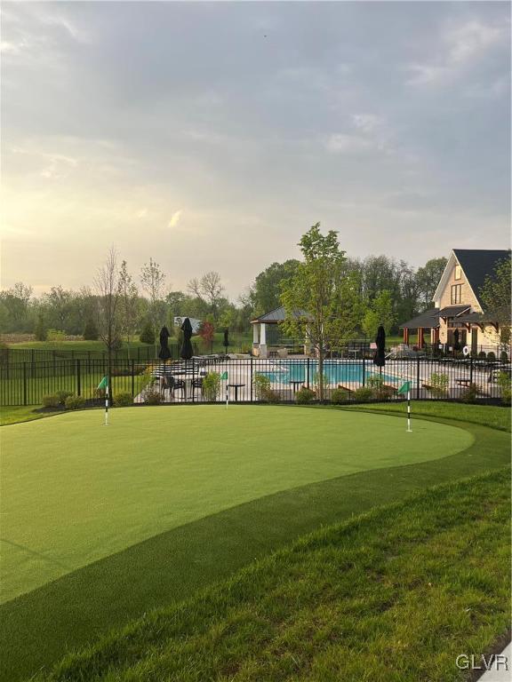 view of property's community featuring a pool and fence