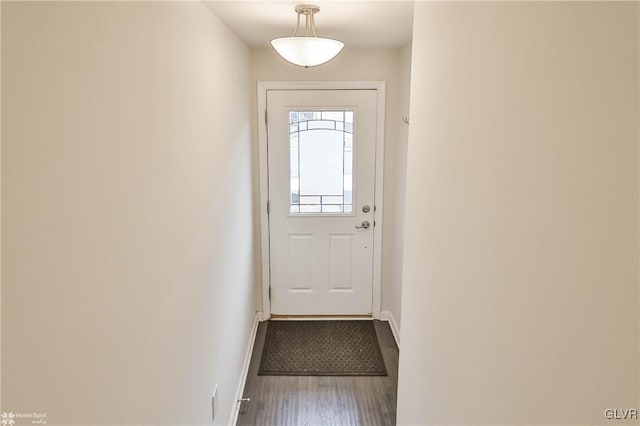 doorway to outside featuring baseboards and wood finished floors