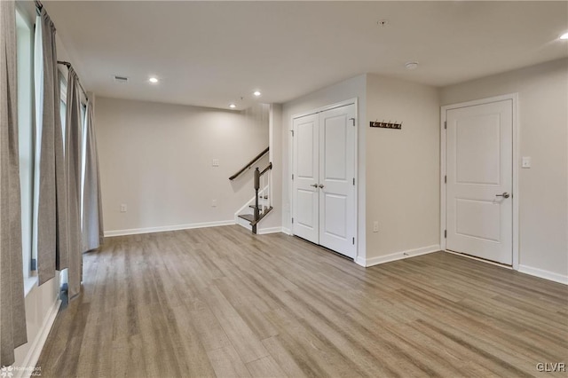 interior space with light wood-style floors, recessed lighting, baseboards, and stairs