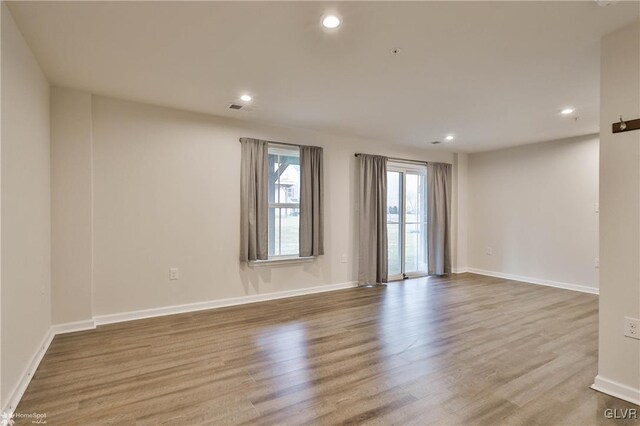 spare room with baseboards, wood finished floors, visible vents, and recessed lighting