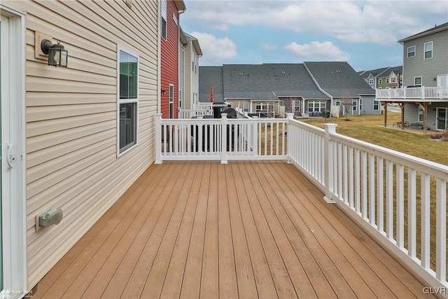 wooden terrace with a residential view and a yard