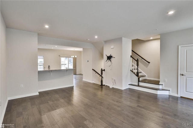 unfurnished living room featuring baseboards, dark wood-type flooring, and recessed lighting