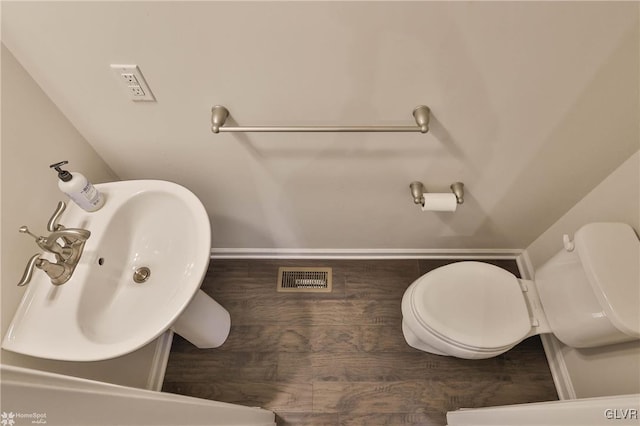 bathroom with visible vents, a sink, toilet, and wood finished floors