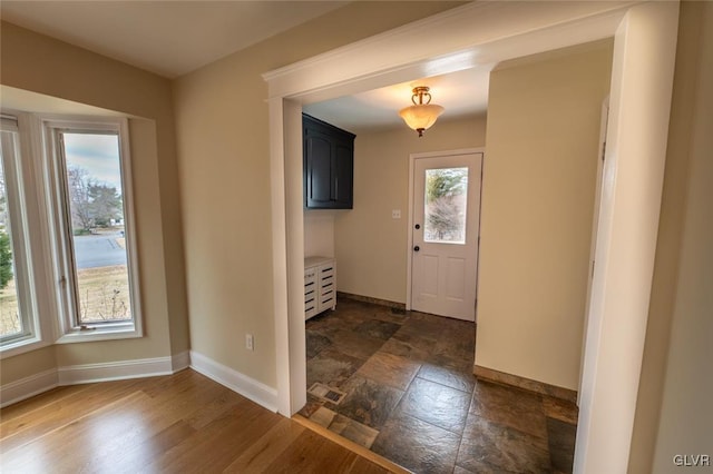 entryway with stone finish flooring, plenty of natural light, and baseboards