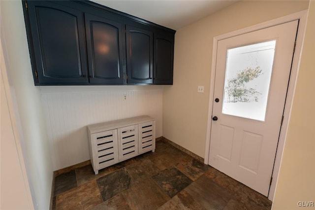 entryway featuring baseboards and stone finish floor