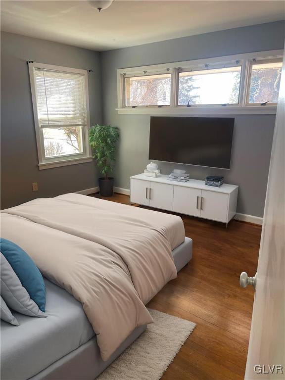 bedroom featuring baseboards and wood finished floors