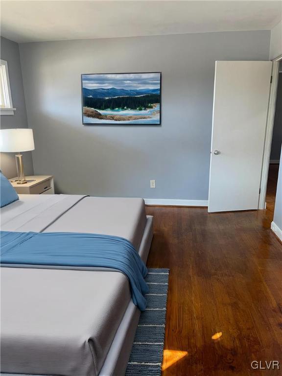 bedroom featuring baseboards and wood finished floors