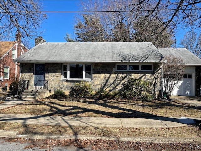 single story home featuring a garage, driveway, stone siding, a chimney, and roof with shingles