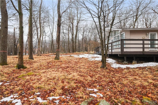 snowy yard featuring a wooden deck