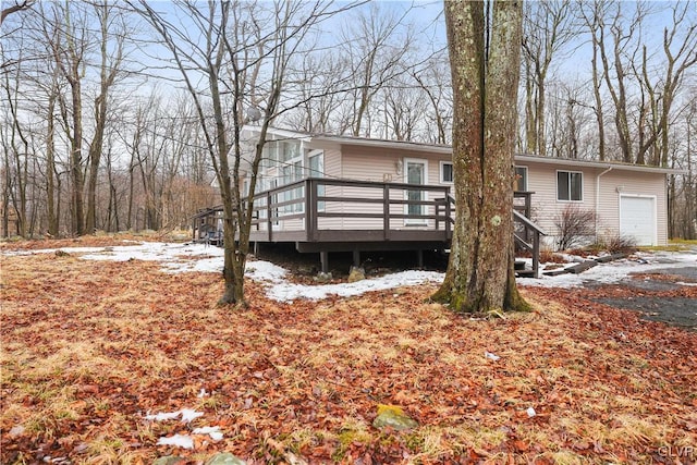 view of front facade with an attached garage and a wooden deck