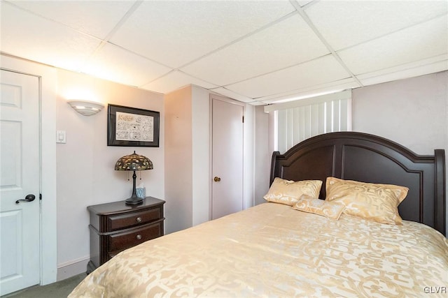 bedroom with a paneled ceiling and baseboards