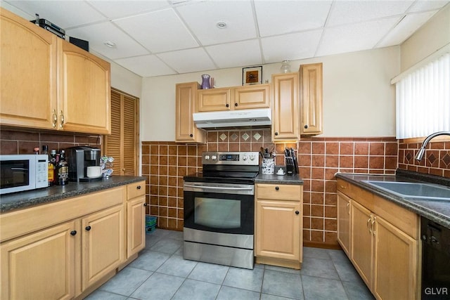 kitchen featuring white microwave, under cabinet range hood, electric range, a sink, and black dishwasher