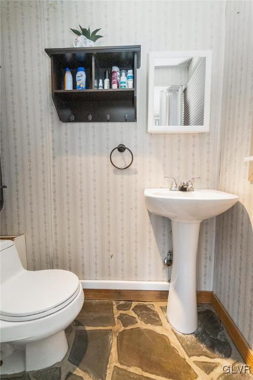 bathroom with wood finished floors, toilet, baseboards, and wallpapered walls