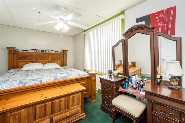 bedroom featuring a drop ceiling and dark carpet