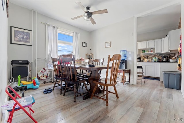 dining space with light wood-style floors and ceiling fan