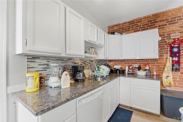 kitchen featuring stone counters, white cabinetry, dishwasher, and decorative backsplash