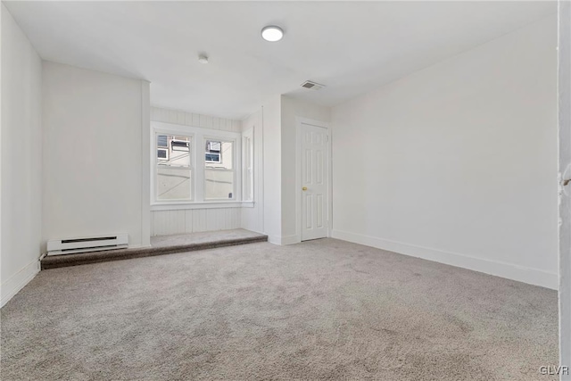 empty room featuring a baseboard heating unit, carpet, visible vents, and baseboards