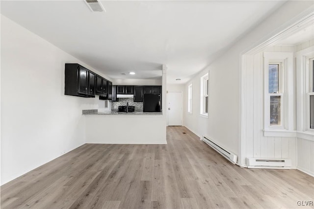 kitchen featuring a baseboard radiator, visible vents, dark cabinetry, and black refrigerator