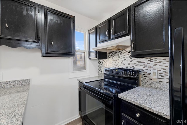 kitchen with under cabinet range hood, electric range, backsplash, and dark cabinetry