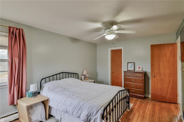 bedroom with light wood-style floors, baseboards, ceiling fan, and baseboard heating