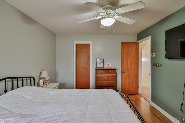 bedroom featuring ceiling fan, baseboards, and wood finished floors