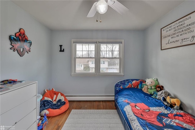 bedroom with ceiling fan, baseboard heating, and wood finished floors