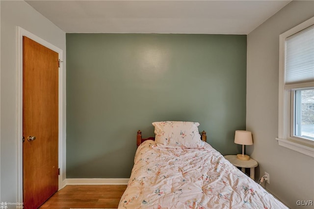 bedroom featuring baseboards and wood finished floors