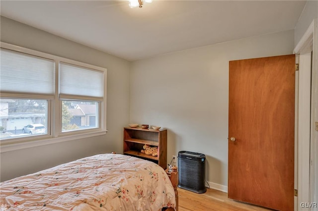 bedroom with light wood-style flooring and baseboards