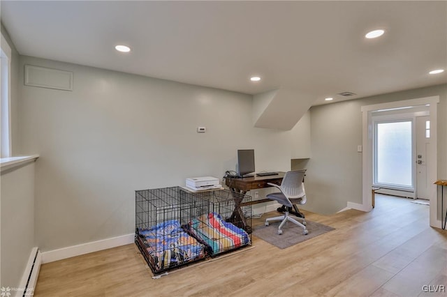 office space featuring recessed lighting, visible vents, a baseboard heating unit, wood finished floors, and baseboards