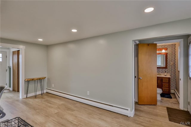 interior space featuring baseboards, a baseboard radiator, light wood-type flooring, a wealth of natural light, and recessed lighting