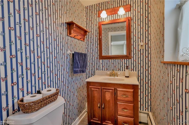 half bathroom featuring vanity, toilet, and wallpapered walls