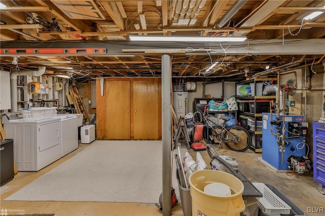 unfinished basement featuring water heater, a heating unit, and washer and clothes dryer