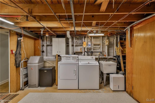 washroom with a sink, laundry area, and washing machine and clothes dryer