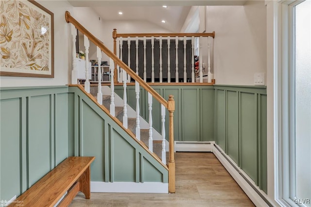 staircase featuring recessed lighting, wainscoting, a decorative wall, and wood finished floors