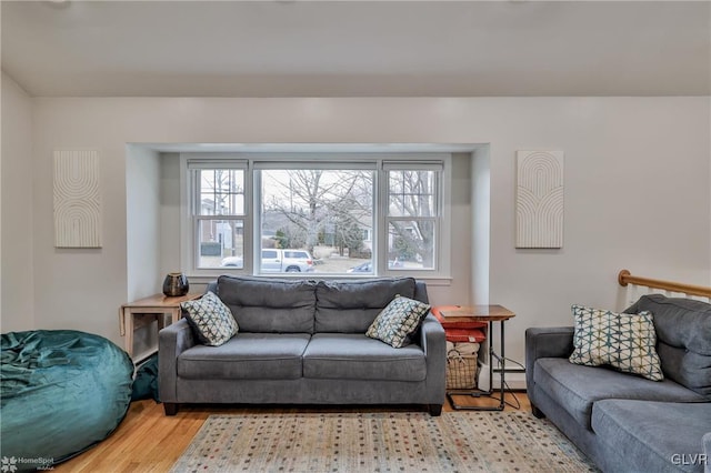 living room with baseboard heating and wood finished floors