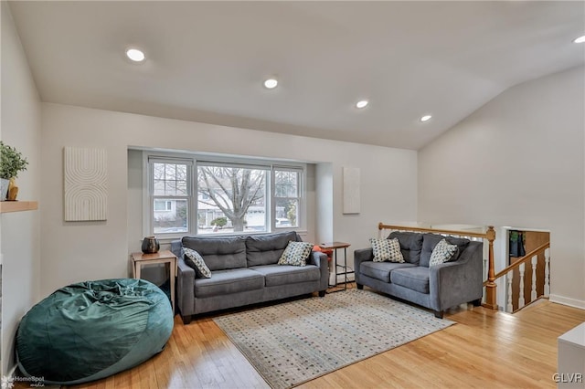 living area featuring lofted ceiling, a baseboard radiator, wood finished floors, and recessed lighting