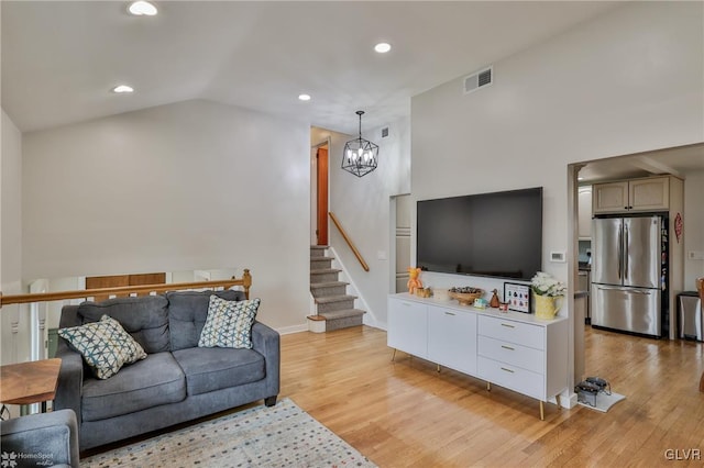 living room with a chandelier, light wood-style flooring, recessed lighting, visible vents, and vaulted ceiling