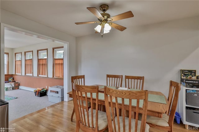 dining area with a ceiling fan and light wood-type flooring