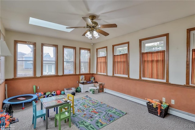 rec room featuring plenty of natural light, a skylight, a baseboard radiator, and carpet flooring