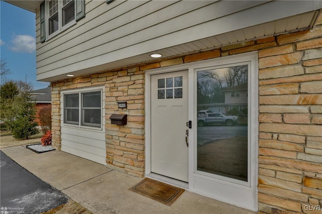 property entrance featuring stone siding