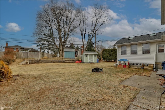 view of yard featuring an outbuilding, a shed, and fence